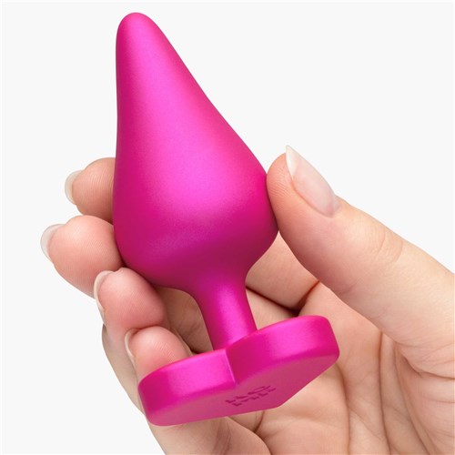 Romp Luster Anal Training Kit hand holding pink plug